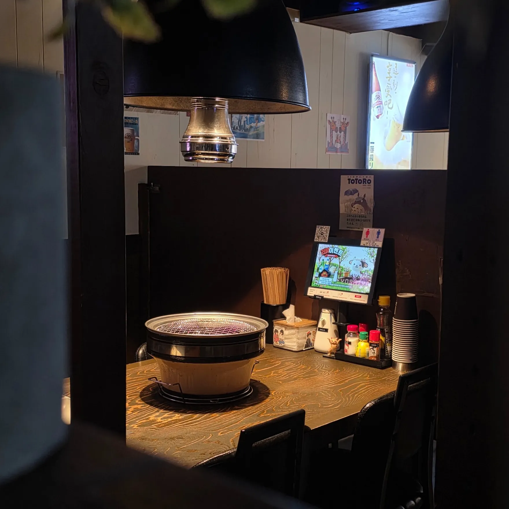 창가 좌석과 숯불 화로가 놓인 요시야 야키니쿠 매장 내부